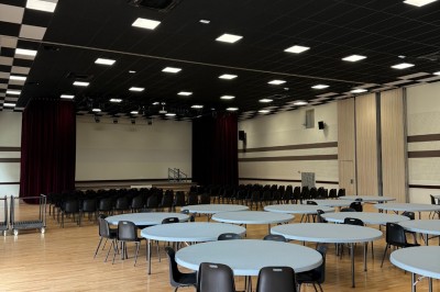 Miniature Location salle Erquy (Côtes-d'Armor) - Orion Evénement #2 Vue d'un espace de toilettes publiques avec cabines fermées, lavabos et miroir, sol en carrelage noir.