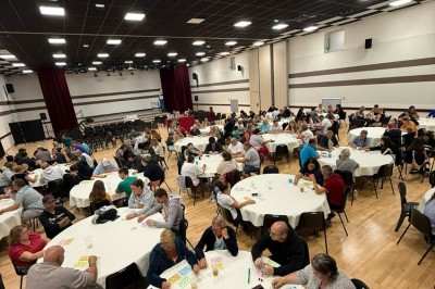 Miniature Location salle Erquy (Côtes-d'Armor) - Orion Evénement #6 Vue d'un espace de toilettes publiques avec cabines fermées, lavabos et miroir, sol en carrelage noir.