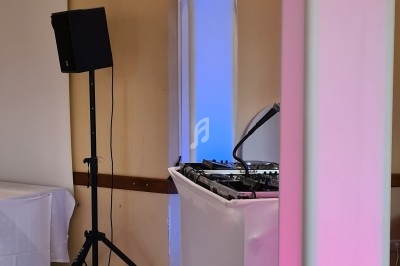 Équipement de sonorisation et éclairage avec projecteurs colorés et table de mixage dans une salle événementielle.
