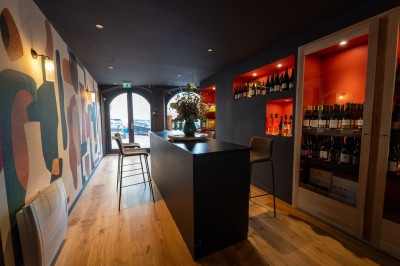 Miniature Location salle Chasselay (Rhône) - La Cave Chez Max #2 Intérieur d'un bar moderne avec un comptoir en bois, des tables hautes et une décoration murale colorée.