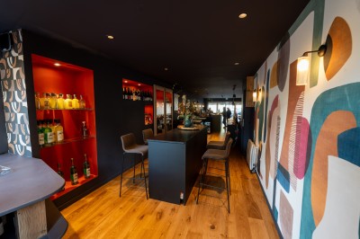 Miniature Location salle Chasselay (Rhône) - La Cave Chez Max #3 Intérieur d'un bar moderne avec un comptoir en bois, des tables hautes et une décoration murale colorée.