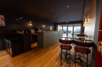 Miniature Location salle Chasselay (Rhône) - La Cave Chez Max #6 Intérieur d'un café moderne avec un comptoir en bois, des tables hautes et une décoration murale colorée.