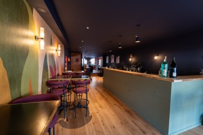 Miniature Location salle Chasselay (Rhône) - La Cave Chez Max #7 Intérieur d'un café moderne avec un comptoir en bois, des tables hautes et une décoration murale colorée.