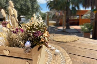 Table en bois garnie de divers plats, pains, charcuteries et amuse-bouches, présentés pour un buffet en extérieur.