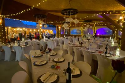 Table en bois garnie de divers plats, pains, charcuteries et amuse-bouches, présentés pour un buffet en extérieur.