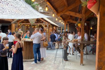 Table en bois garnie de divers plats, pains, charcuteries et amuse-bouches, présentés pour un buffet en extérieur.