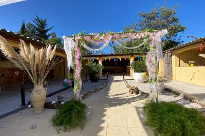 Table en bois garnie de divers plats, pains, charcuteries et amuse-bouches, présentés pour un buffet en extérieur.