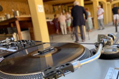 Table en bois garnie de divers plats, pains, charcuteries et amuse-bouches, présentés pour un buffet en extérieur.