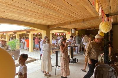 Table en bois garnie de divers plats, pains, charcuteries et amuse-bouches, présentés pour un buffet en extérieur.