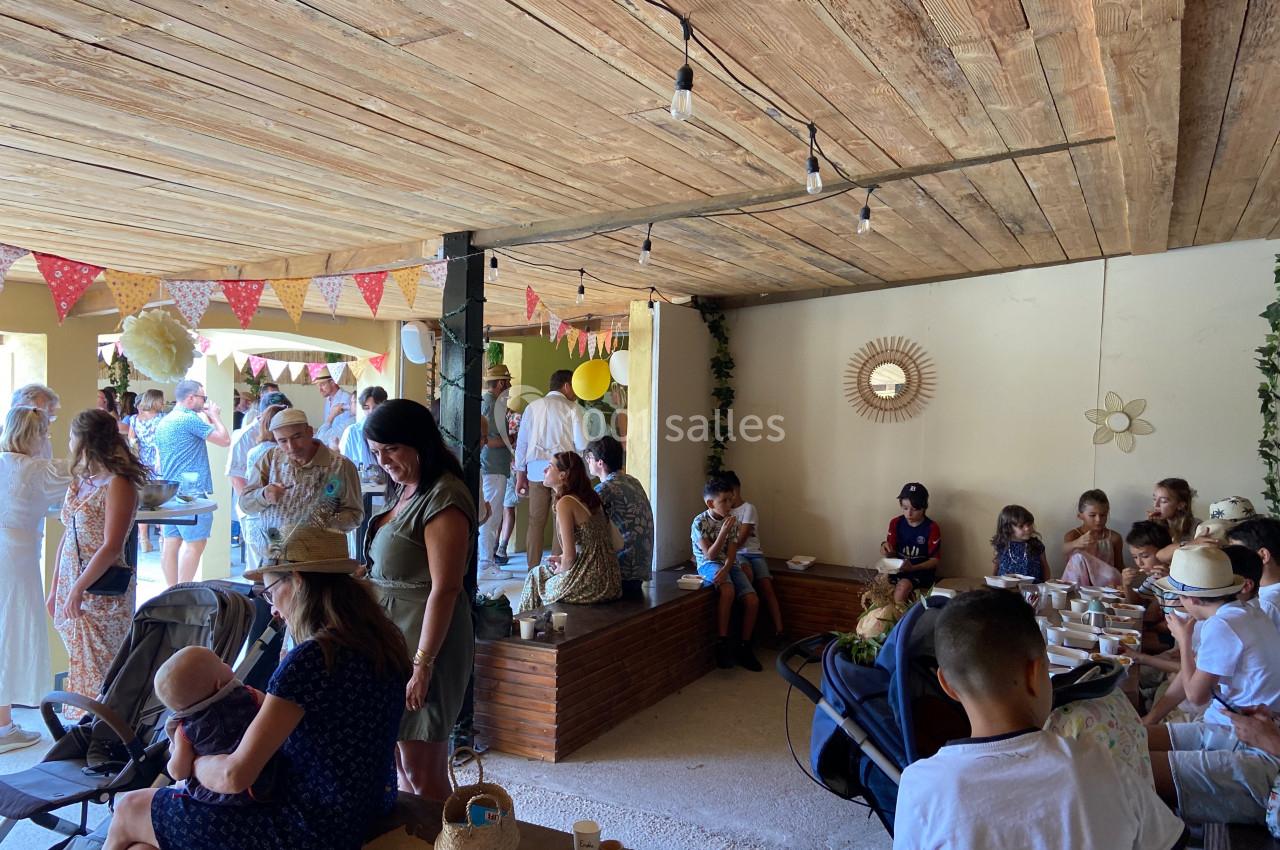 Des personnes rassemblées dans un espace intérieur décoré, discutant et s'occupant d'enfants en poussettes.