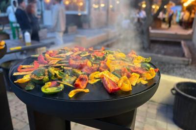 Table en bois garnie de divers plats, pains, charcuteries et amuse-bouches, présentés pour un buffet en extérieur.