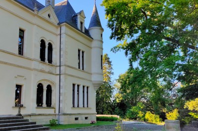 Miniature Location salle Chaptuzat (Puy-de-Dôme) - Château des Bérangers #27 Allée bordée de jeunes arbustes menant à une porte en fer, entourée d'arbres et d'un espace herbeux.