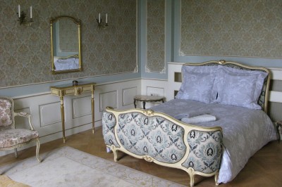 Miniature Chambre Céladone Table élégamment dressée avec fleurs pastel, chandeliers roses torsadés et vaisselle raffinée dans une salle classique.