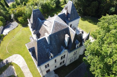 Miniature Château des Bérangers Table élégamment dressée avec fleurs pastel, chandeliers roses torsadés et vaisselle raffinée dans une salle classique.