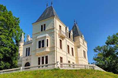 Miniature Château des Bérangers Table élégamment dressée avec fleurs pastel, chandeliers roses torsadés et vaisselle raffinée dans une salle classique.