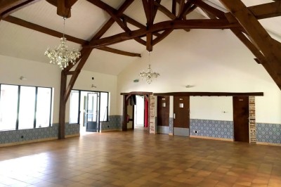 Installation de matériel de sonorisation et d'éclairage dans une salle avec un lustre et un plafond en bois.