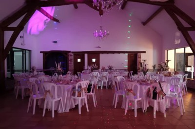 Installation de matériel de sonorisation et d'éclairage dans une salle avec un lustre et un plafond en bois.