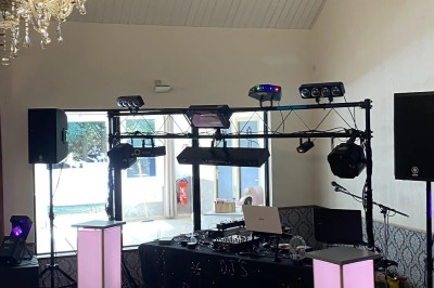 Installation de matériel de sonorisation et d'éclairage dans une salle avec un lustre et un plafond en bois.