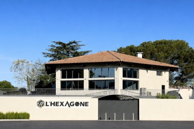 Escalier intérieur éclairé par des lumières au sol, avec une rampe et une porte en fer forgé décorative.