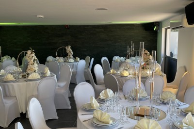 Escalier intérieur éclairé par des lumières au sol, avec une rampe et une porte en fer forgé décorative.