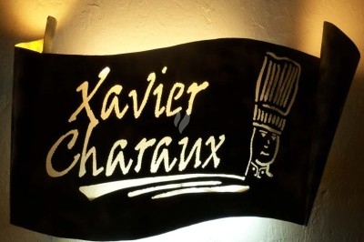 Arrangement floral avec roses blanches, fleurs rouges et feuillage vert, posé sur un cadre rouge sur un sol carrelé.