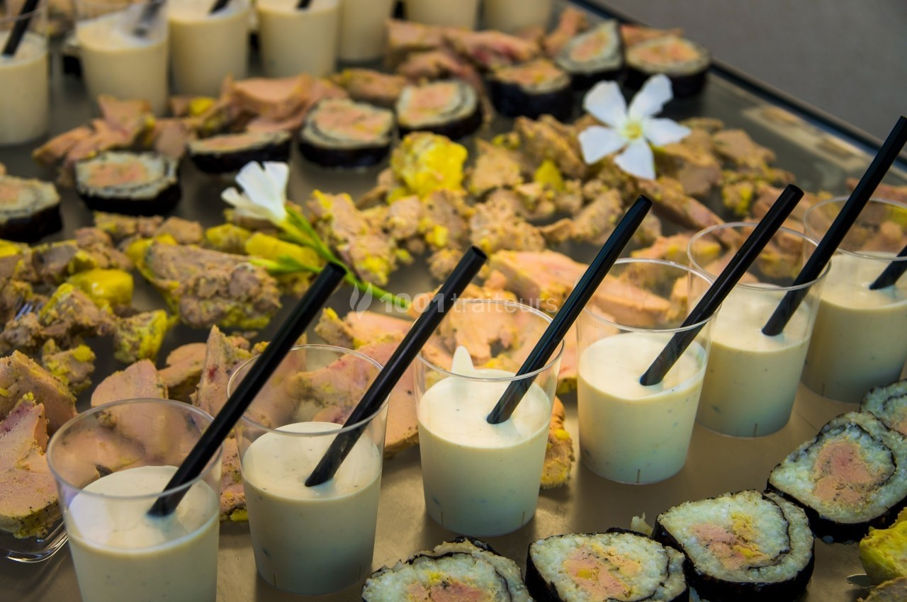 Assortiment de verrines, sushis et toasts garnis de foie gras présenté sur un plateau de réception.