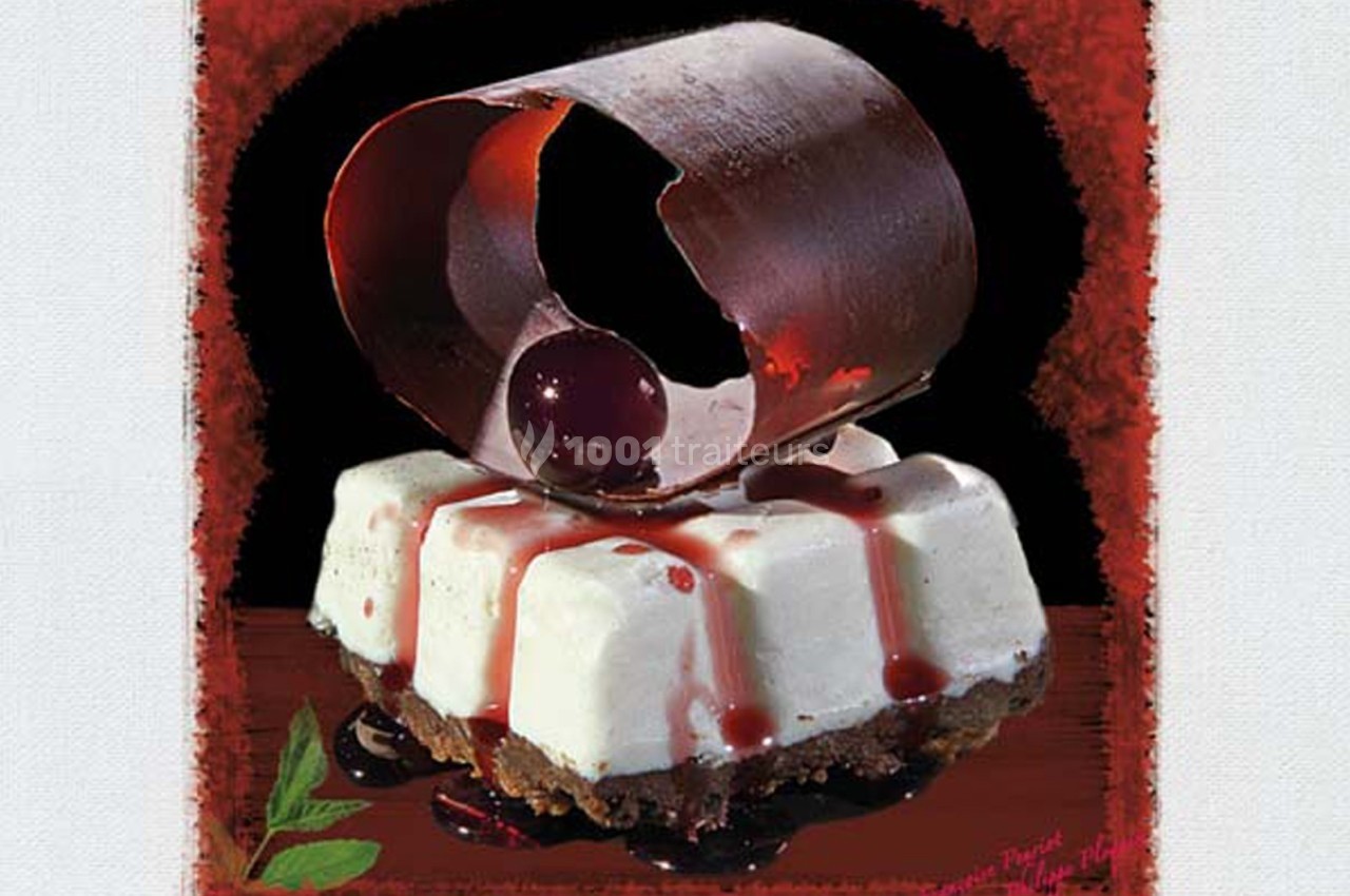 Dessert composé d'une base biscuitée, mousse blanche, coulis de cerises et décor en chocolat avec une cerise.