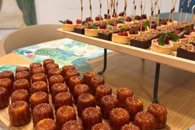 Table ronde dressée pour un repas, avec nappes blanches, couverts, verres, pains et centre de table floral.