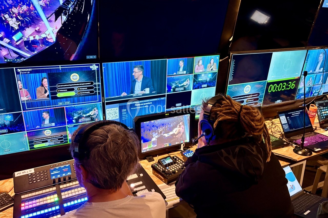 Techniciens supervisant des écrans de contrôle dans une régie pendant la diffusion d'une émission en direct.