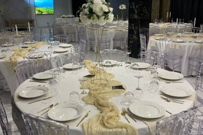 Cuisine professionnelle avec plan de travail en inox, carrelage mural blanc, sol en carrelage gris et équipements basiques.