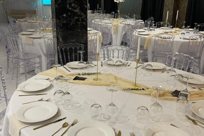 Cuisine professionnelle avec plan de travail en inox, carrelage mural blanc, sol en carrelage gris et équipements basiques.