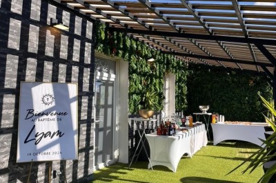 Cuisine professionnelle avec plan de travail en inox, carrelage mural blanc, sol en carrelage gris et équipements basiques.