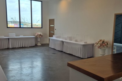 Miniature Location salle Épinay-sur-Seine (Seine-Saint-Denis) - Salle Delena #10 Salle lumineuse avec table ronde dressée, chaises blanches et centre de table floral sous de grandes fenêtres.