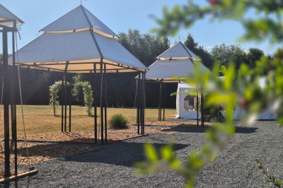 Miniature Location salle Souligné-sous-Ballon (Sarthe) - Le Grand Chêne #3 Deux tonneaux en bois avec parasols sur un sol gravillonné, près d'arbres sous un ciel bleu.