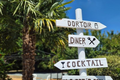 Miniature Location salle Souligné-sous-Ballon (Sarthe) - Le Grand Chêne #6 Deux tonneaux en bois avec parasols sur un sol gravillonné, près d'arbres sous un ciel bleu.