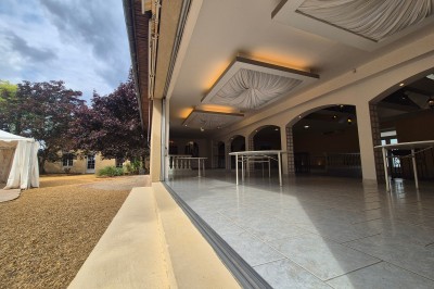 Miniature Location salle Souligné-sous-Ballon (Sarthe) - Le Grand Chêne #11 Deux tonneaux en bois avec parasols sur un sol gravillonné, près d'arbres sous un ciel bleu.
