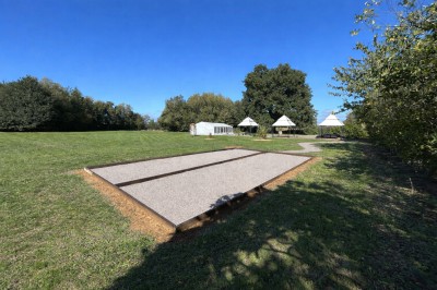 Miniature Location salle Souligné-sous-Ballon (Sarthe) - Le Grand Chêne #4 Deux tonneaux en bois avec parasols sur un sol gravillonné, près d'arbres sous un ciel bleu.