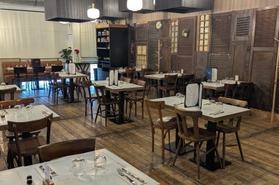 Poulet rôti garni de tranches d'oignon servi dans une assiette, une main utilise une fourchette pour le déguster.