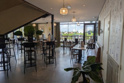 Poulet rôti garni de tranches d'oignon servi dans une assiette, une main utilise une fourchette pour le déguster.