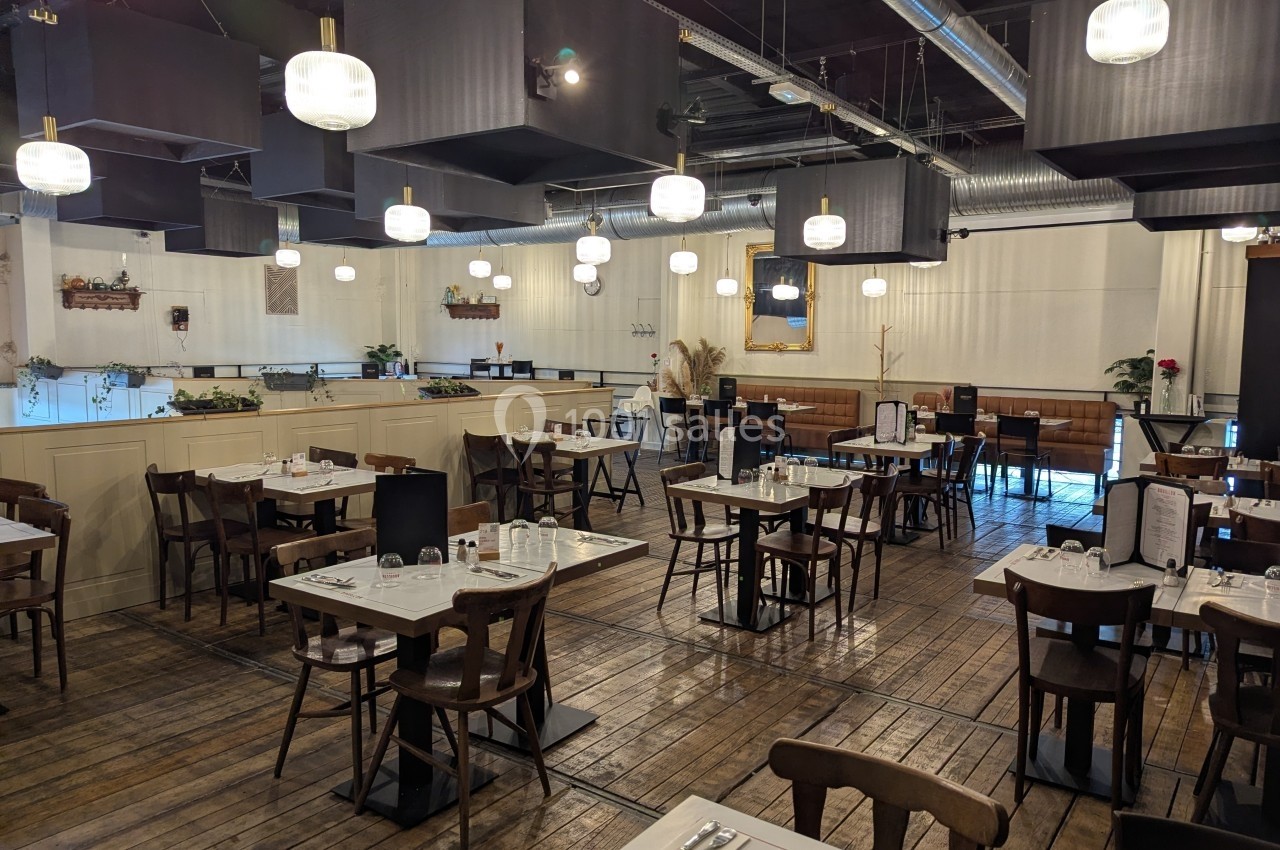 Salle de restaurant lumineuse avec tables en bois, chaises assorties et décor sobre dans un style moderne.