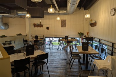 Miniature Mezzanine Poulet rôti garni d'oignons caramélisés sur une assiette, avec une main utilisant une fourchette en arrière-plan.