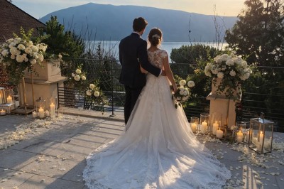 Table extérieure dressée avec des verres à vin, des fleurs, des bougies et des plateaux de nourriture.