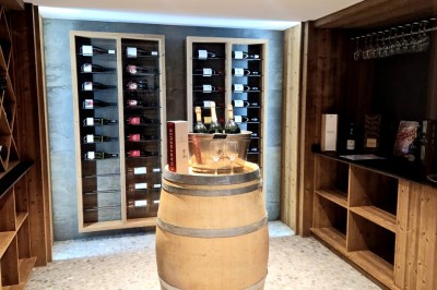 Table extérieure dressée avec des verres à vin, des fleurs, des bougies et des plateaux de nourriture.