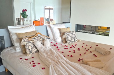 Table extérieure dressée avec des verres à vin, des fleurs, des bougies et des plateaux de nourriture.