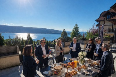 Table extérieure dressée avec des verres à vin, des fleurs, des bougies et des plateaux de nourriture.