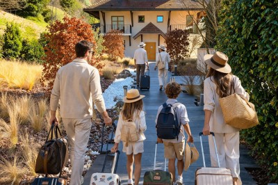 Table extérieure dressée avec des verres à vin, des fleurs, des bougies et des plateaux de nourriture.