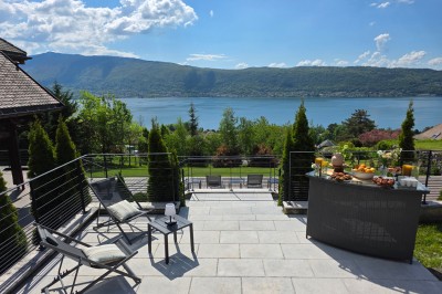 Table extérieure dressée avec des verres à vin, des fleurs, des bougies et des plateaux de nourriture.
