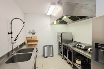 Table extérieure dressée avec des verres à vin, des fleurs, des bougies et des plateaux de nourriture.