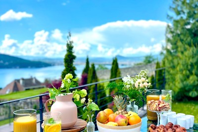 Table extérieure dressée avec des verres à vin, des fleurs, des bougies et des plateaux de nourriture.