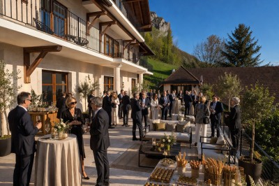 Table extérieure dressée avec des verres à vin, des fleurs, des bougies et des plateaux de nourriture.